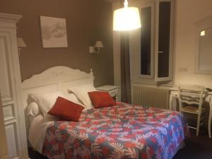 - une chambre avec un lit doté de 2 oreillers rouges dans l'établissement HOTEL LES MARRONNIERS, à Thueyts