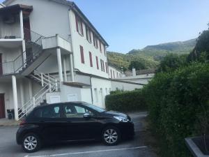 une voiture noire garée devant un bâtiment dans l'établissement HOTEL LES MARRONNIERS, à Thueyts