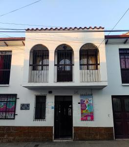 een wit gebouw met zwarte ramen bij Spanish Friends in Sucre