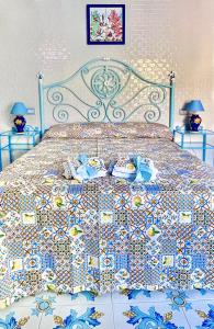 a bedroom with a bed with a colorful bedspread at AMALFI ROOM ~ Camera indipendente con Bagno interno per Max 3/4 Persone in Palinuro