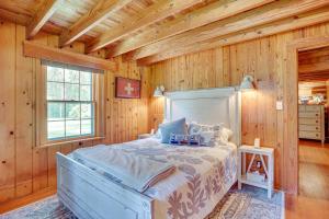 a bedroom with a bed in a room with wooden walls at Virginia Retreat on Wicomico River with Dock! in Reedville