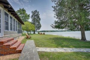 a house with a bench next to the water at Virginia Retreat on Wicomico River with Dock! in Reedville