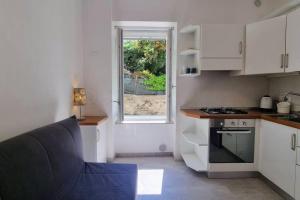 a small kitchen with a stove and a window at La Casa degli Artisti in Trieste