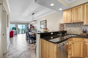 a kitchen with wooden cabinets and a dining room at FFR101 - The Wright Idea in Kill Devil Hills