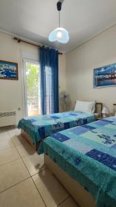 a bedroom with two beds and a window at Sunny Family Apartment in Iraklitsa