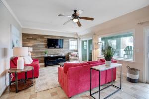 a living room with a red couch and a ceiling fan at FFR101 - The Wright Idea in Kill Devil Hills
