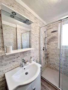 y baño blanco con lavabo y ducha. en Torino Casa Maria - 2 Bedroom Apartment, en Turín