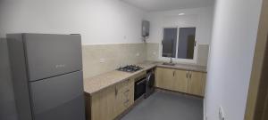 a kitchen with a refrigerator and a stove top oven at Logement familial in Selouane