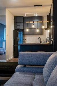 a kitchen with a couch and a kitchen with a refrigerator at Apartament Klonowa z garażem podziemnym in Kielce