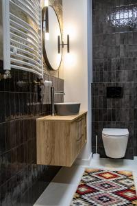 La salle de bains est pourvue d'un lavabo et de toilettes. dans l'établissement Apartament Klonowa z garażem podziemnym, à Kielce