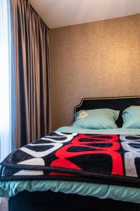 - une chambre avec un lit et une couverture colorée dans l'établissement Apartament Klonowa z garażem podziemnym, à Kielce