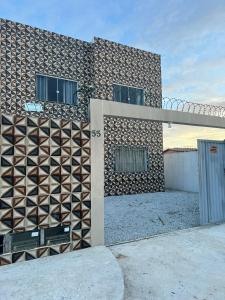 un edificio con un diseño geométrico en su lateral en Residencial Casa Grande - Apto 02, en Santa Cruz Cabrália