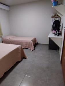 Habitación con 2 camas, mesa y barra. en Residencial Casa Grande - Apto 02, en Santa Cruz Cabrália