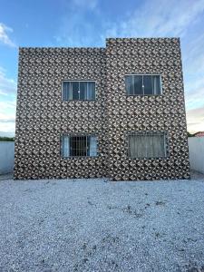 a building with three windows on the side of it at Residencial Casa Grande - Apto 02 in Santa Cruz Cabrália