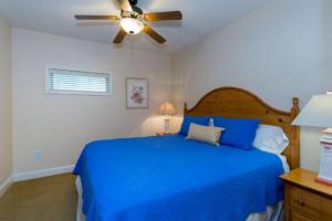 a bedroom with a blue bed with a ceiling fan at FFR202 - Atlantic Splash in Kill Devil Hills +29 photos