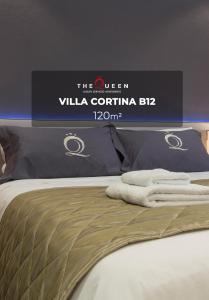 uma cama com uma placa que diz a rainha villa corina em The Queen Luxury Apartments - Villa Cortina em Luxemburgo