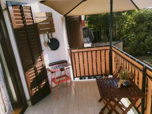 a balcony with an umbrella and a bench and a table at Superior Familiy Apartment Tina in Vrsar