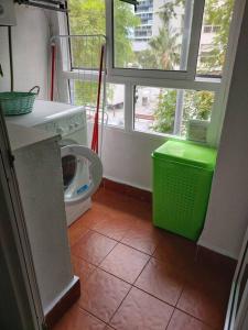 a laundry room with a washing machine and a window at Apartamento La Porteña, 200 ms de playa Victoria in Cádiz