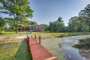 a wooden bridge over a river in front of a house at Bright Bluemont Home with On-Site Pond and Mtn Views! in Paris