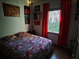 - une chambre avec un lit et une fenêtre avec des rideaux rouges dans l'établissement Mas de la Villardière, à Raphèle