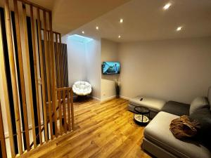 a living room with a couch and a flat screen tv at Katrine in Saint-Étienne