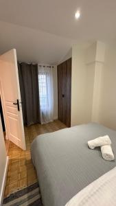 1 dormitorio con 1 cama con 2 toallas en Katrine, en Saint-Étienne