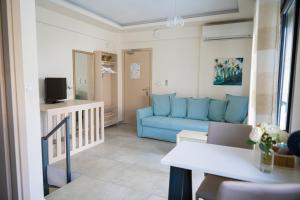 een woonkamer met een blauwe bank en een tafel bij Callista Suites in Flogita