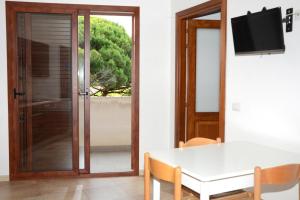 comedor con mesa y puerta corredera de cristal en Appartamenti Fronte mare en Siniscola