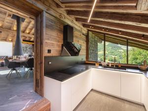 kuchnia z białymi szafkami i dużym oknem w obiekcie Chalet de prestige avec jacuzzi, sauna et cinéma - FR-1-570-42 w mieście Saint-Martin-de-Belleville