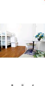 Guest House Izola في إيزولا: غرفة نوم مع سرير ومكتب مع إناء من الزهور