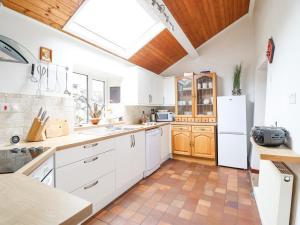 a kitchen with white cabinets and a skylight at Haulfryn in Bangor