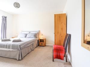 a bedroom with a bed and a chair in it at Haulfryn in Bangor