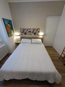 a large white bed in a room with two lights at Nido d'amore a Ventimiglia in Ventimiglia