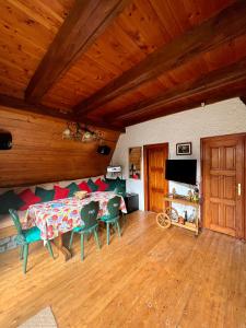 un ampio soggiorno con tavolo e sedie di Mountain Getaway Cabin a Cheia