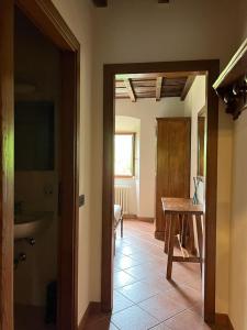 einen Flur mit einem Zimmer mit einem Tisch und einem Zimmer mit einem Tisch in der Unterkunft Agriturismo La Selva di Frena in Firenzuola