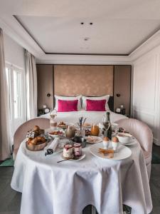Fauchon l'Hôtel Paris في باريس: طاولة عليها طعام مقابل سرير