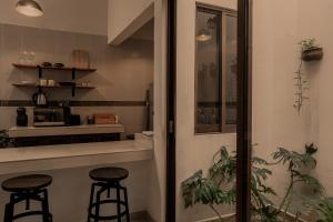 a kitchen with two bar stools and a counter at Narrativ Lofts - Serena - Beautiful Colonial Suite in Campeche