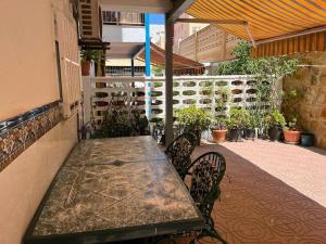 una mesa y sillas en un patio con plantas en Casa Denise en Playa de Gandia