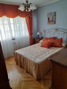 1 dormitorio con 1 cama con almohadas de color naranja en Atico augaboa, en Cangas de Morrazo