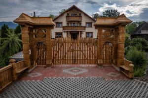 a wooden gate in front of a house at Pensiunea Marioara in Breb