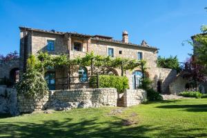 an old stone house with a stone wall at Borgo Pignano in Pignano