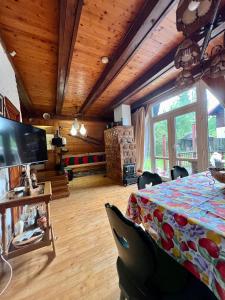 un soggiorno con tavolo e TV di Mountain Getaway Cabin a Cheia