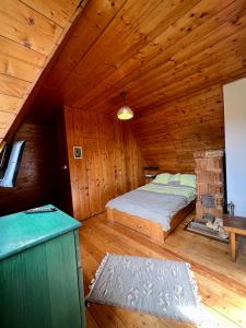 - une chambre avec un lit dans une cabane en bois dans l'établissement Mountain Getaway Cabin, à Cheia