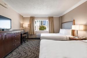 a hotel room with two beds and a flat screen tv at Jack London Inn in Oakland