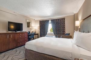 a hotel room with a large bed and a television at Jack London Inn in Oakland