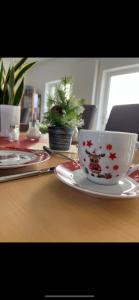 eine Kaffeetasse auf einem Teller auf einem Tisch in der Unterkunft Hotel Bannewitz in Bannewitz