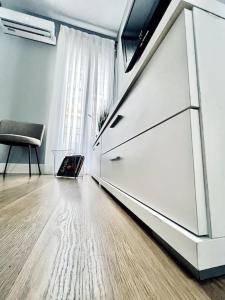 a living room with a white refrigerator and a chair at Hostfy Centro, Plaza de la Magdalena in Seville