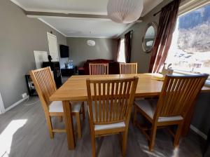 a dining room with a wooden table and chairs at Overnating i Sauda in Sauda