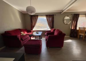 a living room with two red couches and a table at Overnating i Sauda in Sauda