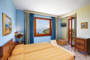 een slaapkamer met een bed en een raam bij Johanna Park Hotel in Sorrento